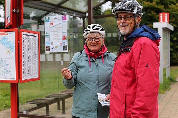 Fahrgäste informieren sich über die neuen Linien an der Haltestelle 