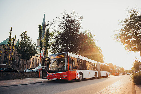 Bus an Haltestelle im Sonnenuntergang