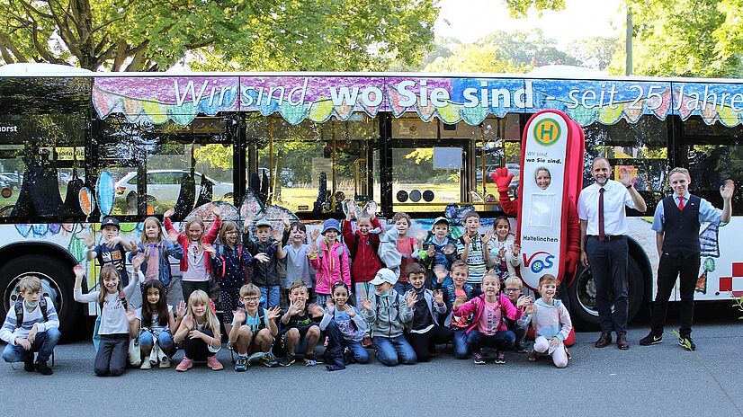 Malwettbewerb Grundschüler Lechtingen vor Bus mit VOS Maskottchen Haltelinchen.