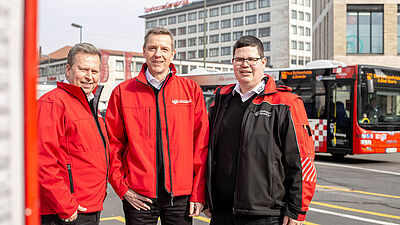 Drei V O S Mobilitätsberater in roter Arbeitsjacke.