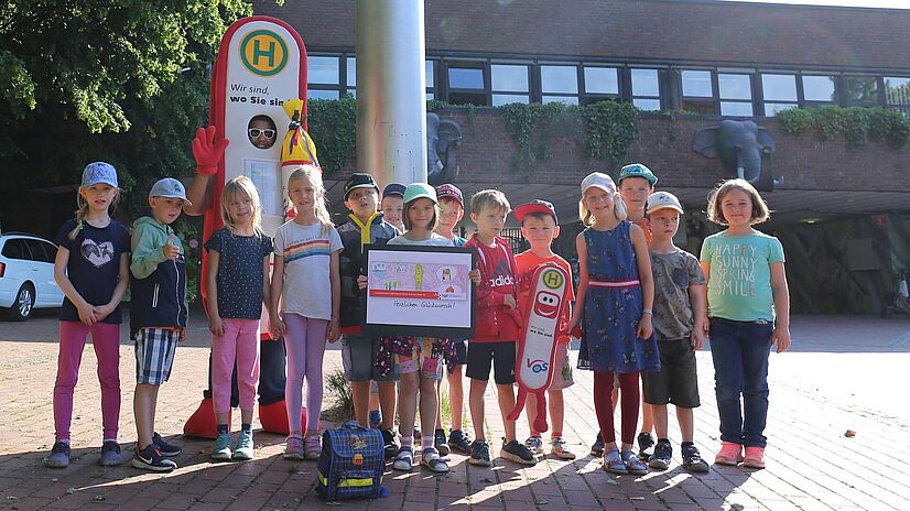 Die i - Männchen Grundschüler aus Bohmte stehen vor dem Eingang des Osnabrücker Zoos.