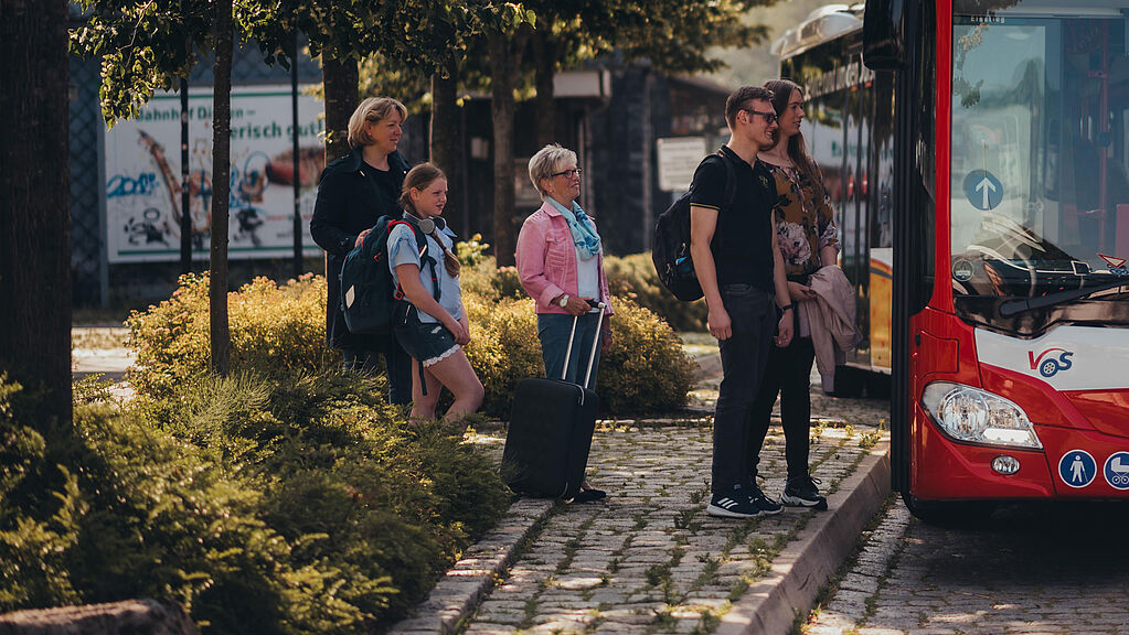 Haltestelle mit Fahrgaesten die in den Bus einsteigen