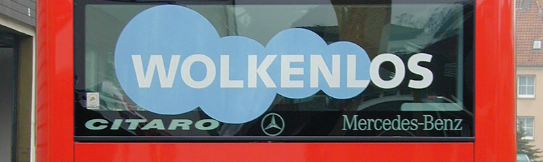 V O S Geschichte 2001. Weißer Schriftzug Wolkenlos mit hellblauen Kreisen dahinter in der Heckscheibe eines Linienbusses.